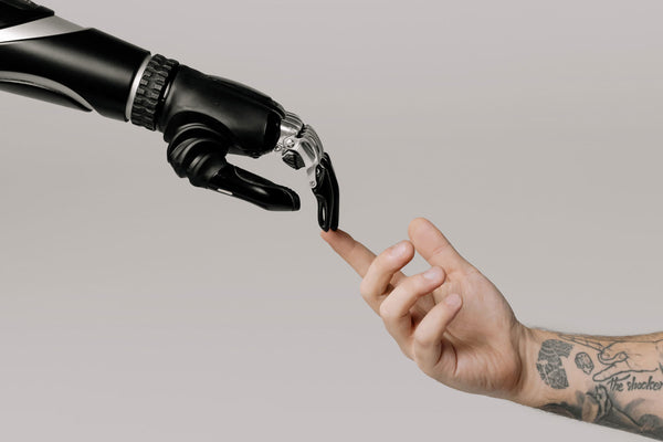 photo of a prosthetic hand touching a human hand